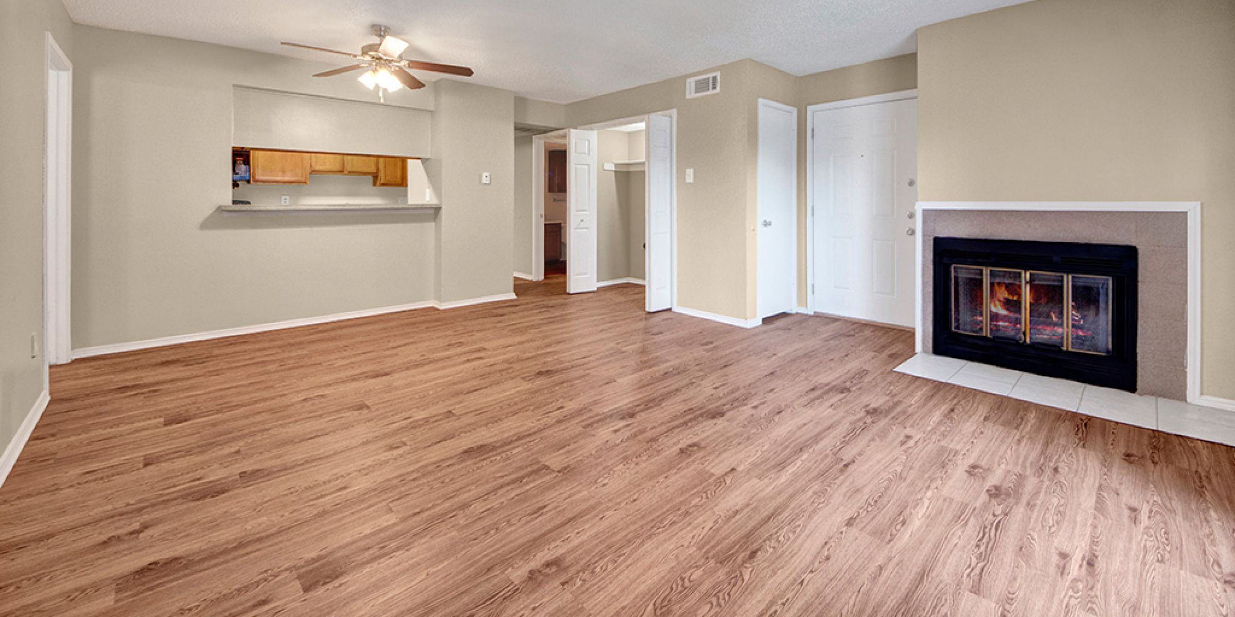 Large open living room with hard wood flooring and a wood burning fireplace